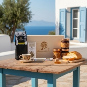 Greek Morning Gift Box with artisanal coffee and honey on a table by the Aegean sea.